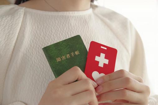 障害者手帳を胸元に持つ女性 障害者手帳を胸元に持つ女性 障害者手帳,障害者,手帳の写真素材
