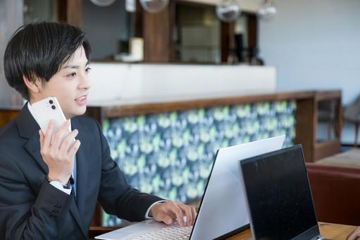 スマホとPC操作する男性 スマホとPC操作する男性 ビジネスマン,スーツ,若者の写真素材