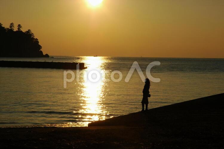 夕暮れに佇む女性 夕日,夕暮れ,女性の写真素材