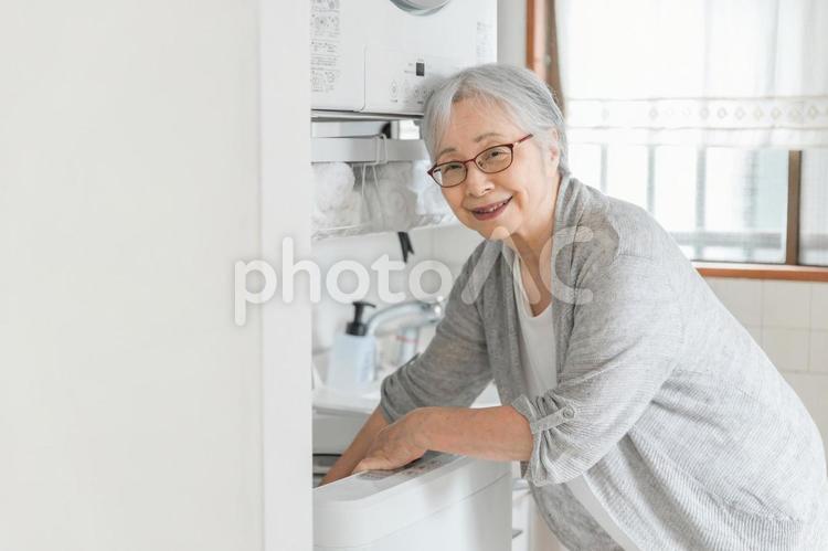 洗濯機を使う高齢者女性 洗濯,高齢者,洗濯物の写真素材