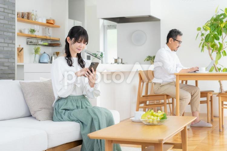 リビングでスマホを見るミドルの夫婦 夫婦,家族,ミドルの写真素材