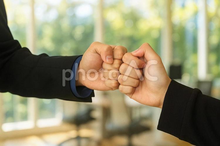 拳を合わせた若い男性 ガッツポーズ,グータッチ,チームワークの写真素材