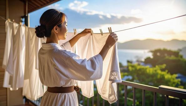 洗濯物を干す女性 洗濯物を干す女性の写真