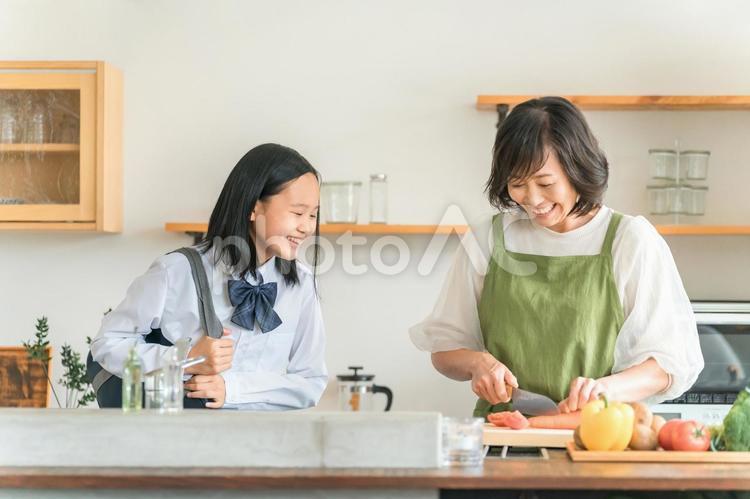 キッチンで料理をする母親と会話する娘 親子,キッチン,朝食の写真素材