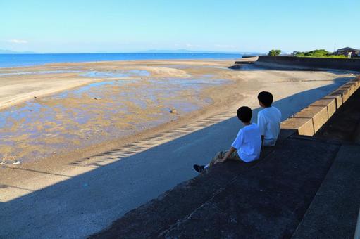 海辺の駅　座って海を眺める男の子　二人 海,空,青空の写真素材