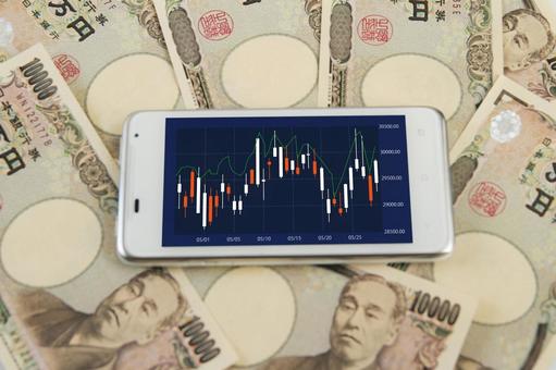 日本円とスマホの株価チャート 日本円とスマホの株価チャート 日本円,紙幣,一万円札の写真素材