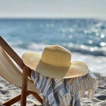 海とビーチとリラックスチェアと麦わら帽子の写真