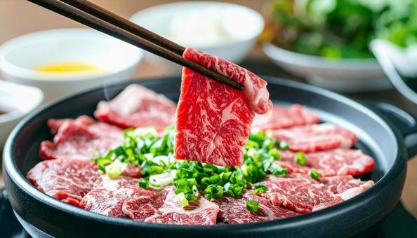 焼肉用の生肉を箸でつまむ 焼肉用の生肉を箸でつまむの写真