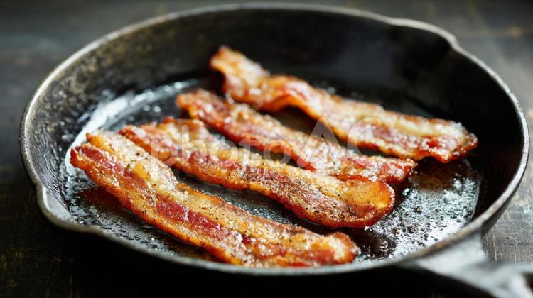鉄のフライパンで焼かれるベーコン ベーコン,肉,豚肉の写真素材