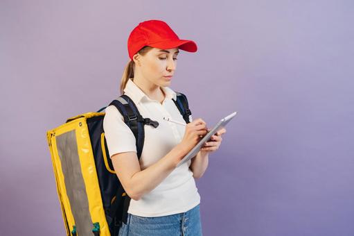 タブレットに入力するフードデリバリーの女性の写真