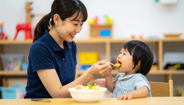 子どもにご飯をあげる保育士 子どもにご飯をあげる保育士の写真