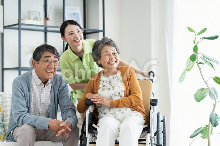 車椅子のシニアの夫婦と介護福祉士 介護,車いす,シニアの写真素材