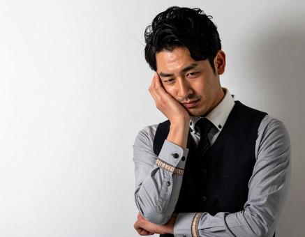 頭を抱えて頭痛に悩む男性 頭を抱えて頭痛に悩む男性の写真