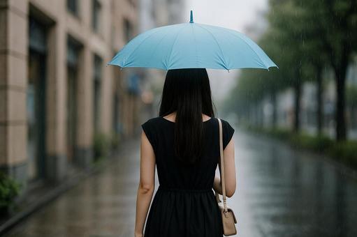 背面から見た雨の日の女性 背面から見た雨の日の女性の写真