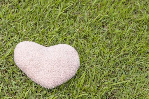 芝生の上に置いたハートのクッション(無人 芝生の上に置いたハートのクッション(無人 ハート,愛,コピースペースの写真素材