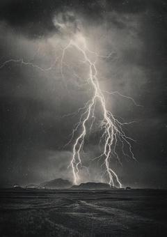 暗雲を裂く一閃の稲光の写真