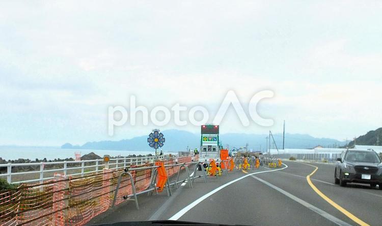 工事のための車線規制と工事前の海岸線道路 工事,工事用車両,車線規制の写真素材