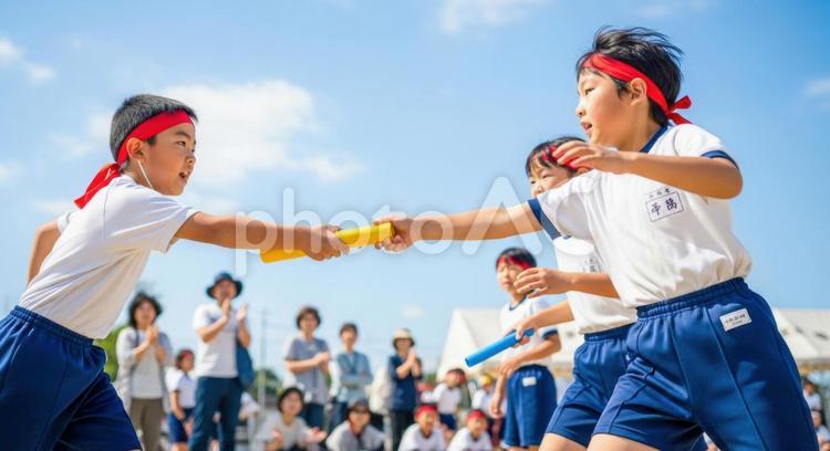 小学生が運動会リレーでバトンを渡す瞬間 小学生,運動会,リレーの写真素材