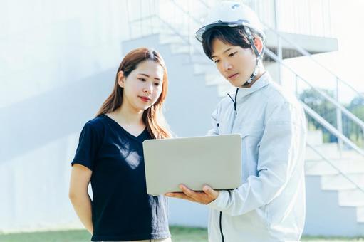 作業着を着た男性がお客様に住宅案内する 住宅,家,マイホームの写真素材