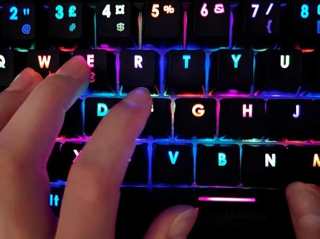 ゲーミングキーボードをタイピングする手元 ゲーミングキーボードをタイピングする手元の写真