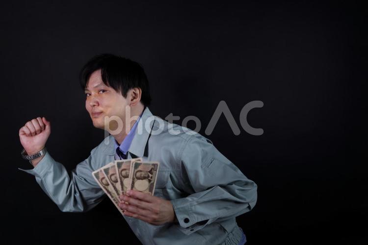 お金を持ち走る作業服男性 作業服,男性,現金の写真素材
