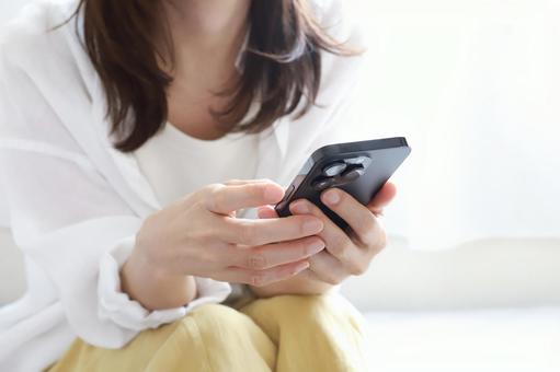 スマートフォンを見る女性 スマートフォンを見る女性の写真