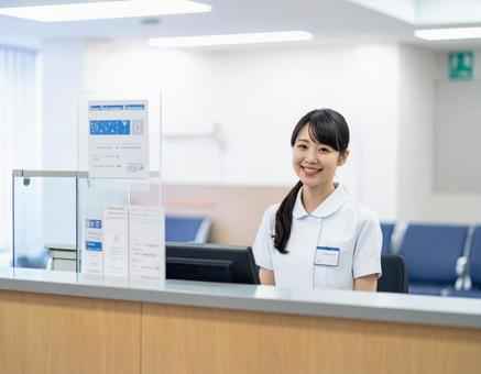 病院の受付コーナーで笑顔で迎える受付嬢 病院の受付コーナーで笑顔で迎える受付嬢の写真