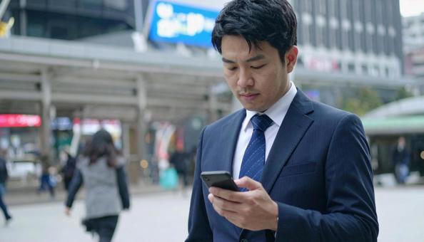 スマホを操作するビジネスマン スマホを操作するビジネスマンの写真