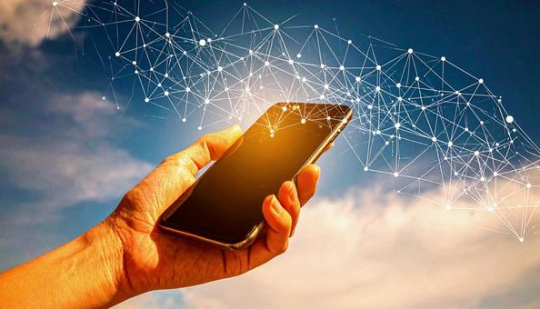 スマートフォンを操作する手 青空背景 スマートフォンを操作する手 青空背景の写真