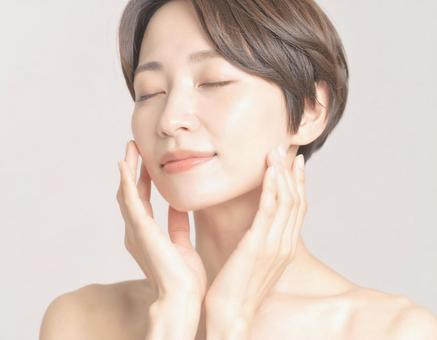 フェイスマッサージをする女性 フェイスマッサージをする女性の写真
