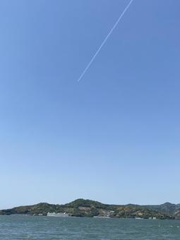 湖の上の青空に描かれた一筋の飛行機雲 湖,飛行機雲,初夏の写真素材