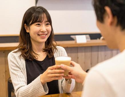 カフェでコーヒーを受け取る女性の写真