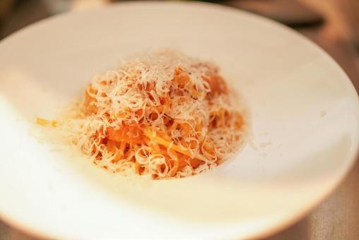 削りたてのチーズをかけたトマトのパスタ 削りたてのチーズをかけたトマトのパスタの写真