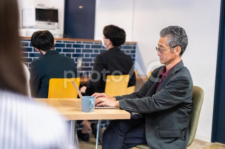 カフェで仕事をする中年男性 カフェ,テレワーク,リモートワークの写真素材