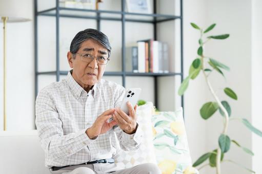 スマホで悩むシニアの男性 スマホで悩むシニアの男性 悩む,シニア,スマホの写真素材
