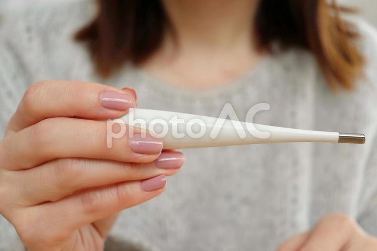 体温計を持つ女性の手 体温計,検温,発熱の写真素材