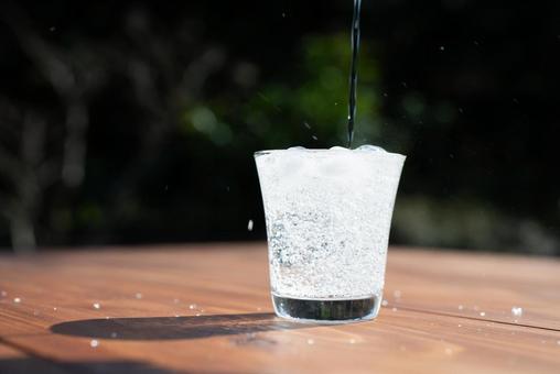 木製テーブルに注がれる炭酸水 木製テーブルに注がれる炭酸水 グラス,炭酸水,水の写真素材