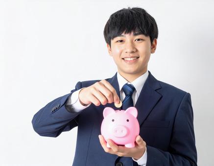 ブタの貯金箱をもつ男の子・男子生徒 ブタの貯金箱をもつ男の子・男子生徒の写真