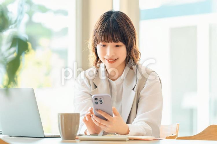 スマホを使う笑顔の女性・ビジネスウーマン 女性,ビジネス,ビジネスウーマンの写真素材