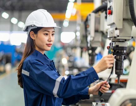工場で機械を組み立てる作業員 工場で機械を組み立てる作業員の写真