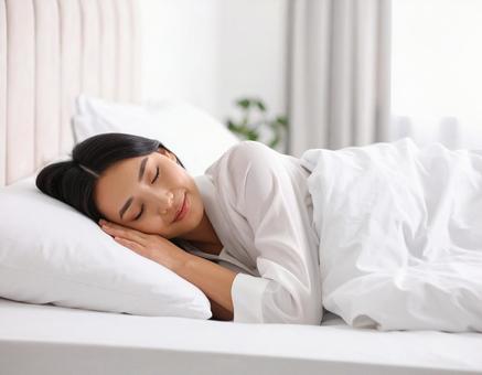 白いリネンのベッドで眠る若い女性 白いリネンのベッドで眠る若い女性の写真