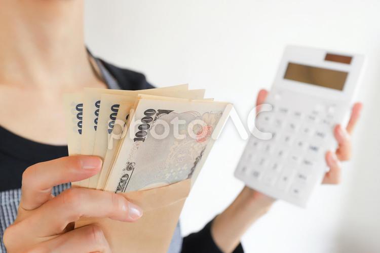 お金と計算機を持った女性 お金,お札,やりくりの写真素材