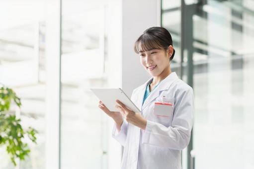 タブレットを操作する若い女性医師 医師,女性,医者の写真素材