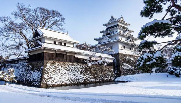 雪化粧した城郭の天守の写真