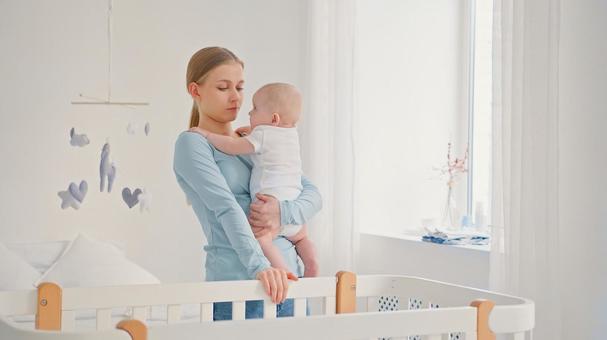 片手で赤ちゃんを抱く女性 片手で赤ちゃんを抱く女性 女性,赤ちゃん,かわいいの写真素材