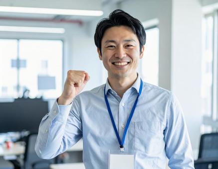 オフィスで笑顔でガッツポーズの男性会社員 オフィスで笑顔でガッツポーズの男性会社員の写真