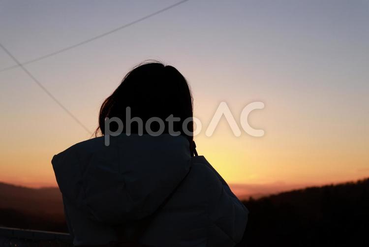 夕景の中の女性のシルエット 冬空,夕日,夕方の写真素材