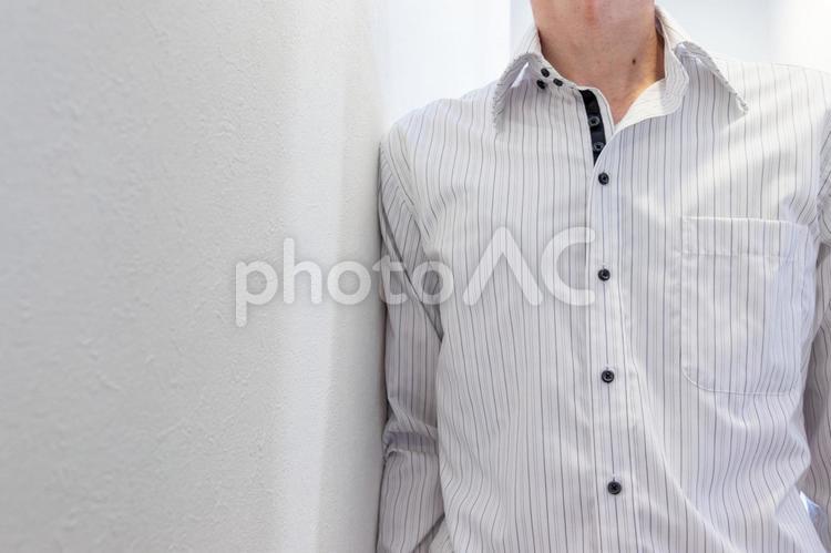 壁にもたれて立つワイシャツ姿の男性 男性,もたれる,壁の写真素材