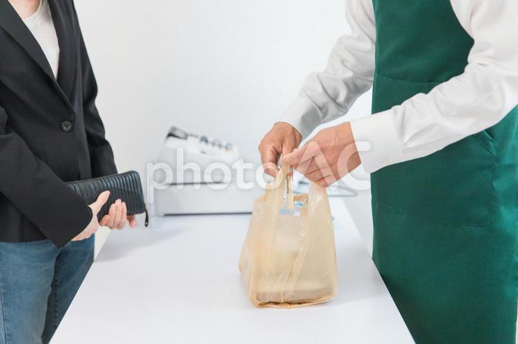 お弁当を買う女性とコンビニ店員（割箸） 割り箸,箸,割箸の写真素材