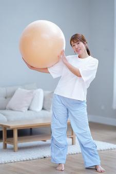 カメラ目線でボールを持つ笑顔の女性 女性,バランスボール,持つの写真素材